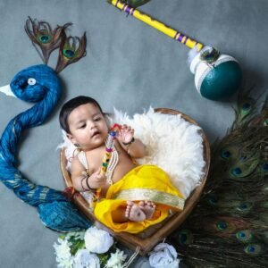 Baby dressed as Krishna in a basket with peacock feathers and a flute.