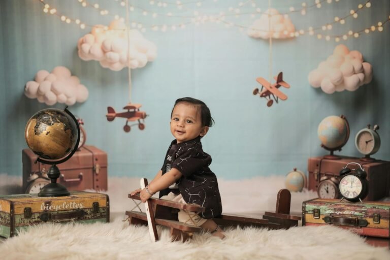 Smiling baby on a wooden toy airplane in a vintage travel themed setup
