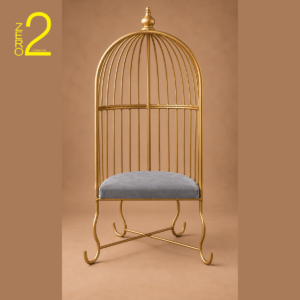 Gold-tone metal baby photography cage chair with a tall rounded backrest, curved legs, and grey cushioned seat.