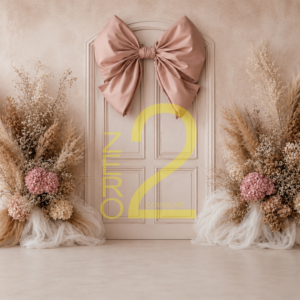 Baby girl photography backdrop with cream paneled door, blush-pink satin bow, and beige floral arrangements