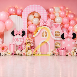 Pink mouse theme first birthday photography backdrop with pink balloon arch, decorative houses, bows and flowers