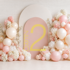 Pastel girl theme photography backdrop with pink balloons, floral decorations and arch panels