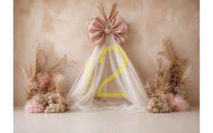 Elegant baby girl photography backdrop with blush-pink bow, white canopy drapes, and floral arrangements