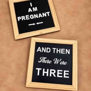 Pregnancy announcement photography props with black letter boards, wooden frames, and white messages reading “I Am Pregnant” and “And Then There Were Three.”