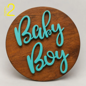 Round brown wood-look baby photography sign with raised turquoise script lettering, shown as the Baby Boy design with a matching Baby Girl version available.