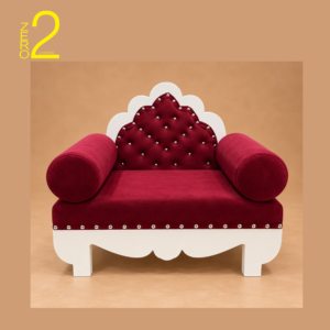 Maharaja baby photography sofa with maroon upholstery, tufted decorative backrest, rounded armrests, and white scalloped base