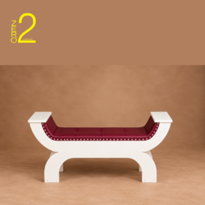 Burgundy upholstered maternity photography sofa with white curved frame and metallic stud detailing